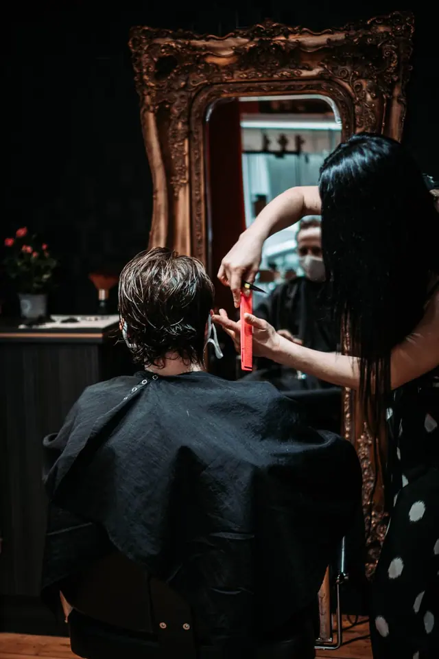 Roxy cutting wet hair with scissors and comb
